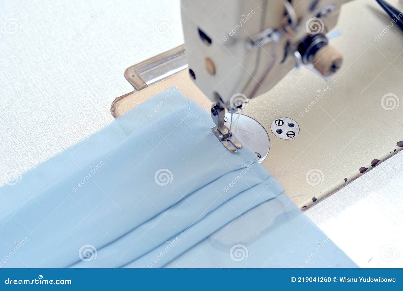 blue cloth using a sewing machine-mesin jahit